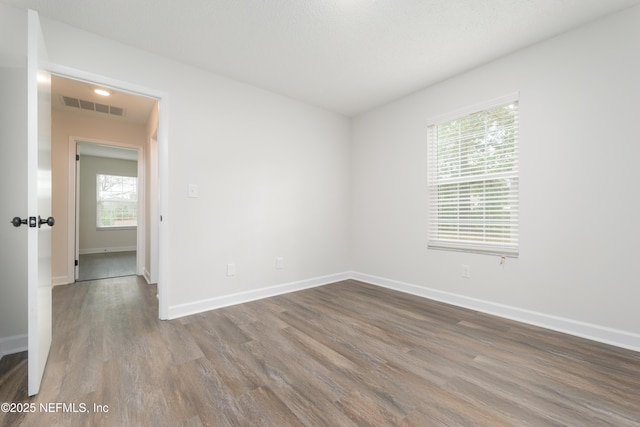 unfurnished room with hardwood / wood-style flooring