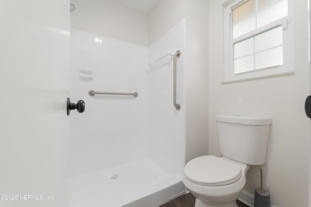 bathroom with tiled shower and toilet