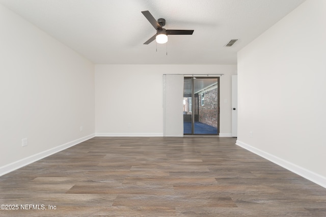 empty room featuring dark hardwood / wood-style flooring, a textured ceiling, and ceiling fan