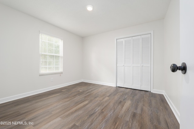 unfurnished bedroom featuring dark hardwood / wood-style floors and a closet