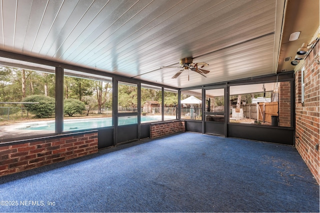 unfurnished sunroom featuring ceiling fan