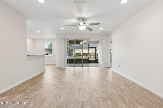 unfurnished living room with ceiling fan, a healthy amount of sunlight, and light wood-type flooring