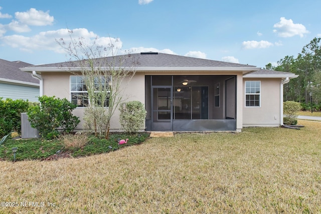 back of property with a sunroom and a lawn