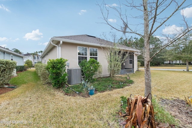 view of side of home with a yard and central air condition unit