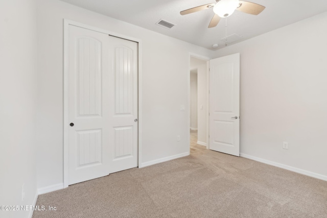 unfurnished bedroom with light colored carpet, ceiling fan, and a closet