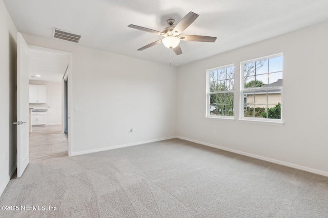 spare room with light carpet and ceiling fan