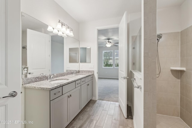 bathroom featuring vanity, tiled shower, and ceiling fan