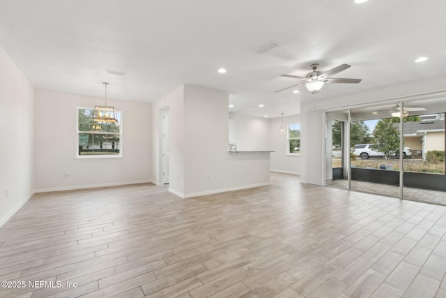 unfurnished living room with a wealth of natural light, ceiling fan, and light hardwood / wood-style flooring