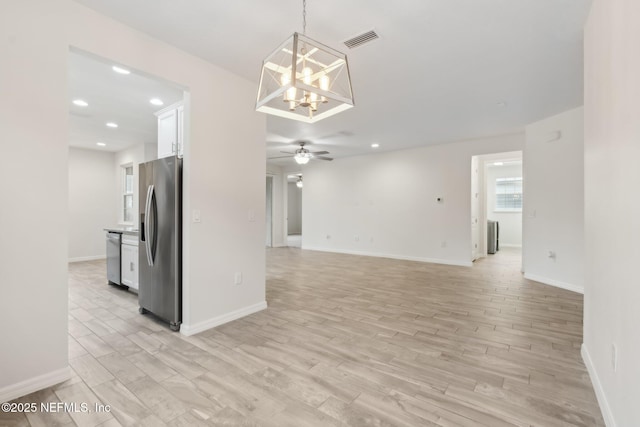 kitchen featuring light hardwood / wood-style flooring, pendant lighting, stainless steel appliances, ceiling fan with notable chandelier, and white cabinets