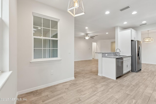 kitchen with sink, white cabinetry, decorative light fixtures, appliances with stainless steel finishes, and ceiling fan