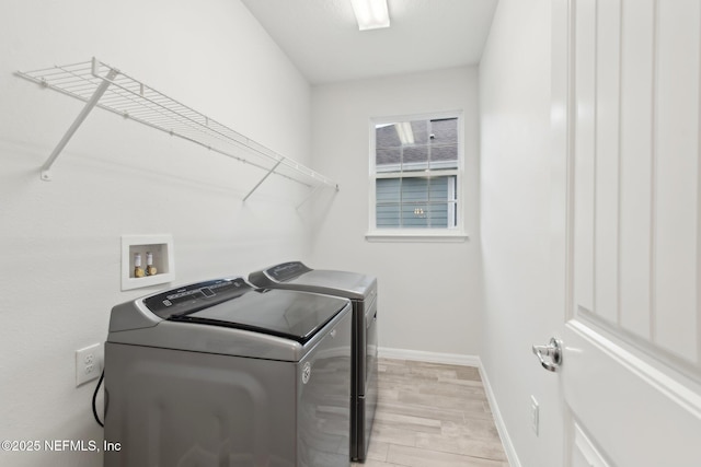 washroom with washer and dryer and light hardwood / wood-style floors