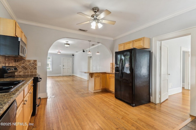 kitchen with appliances with stainless steel finishes, kitchen peninsula, light wood-type flooring, and light brown cabinets