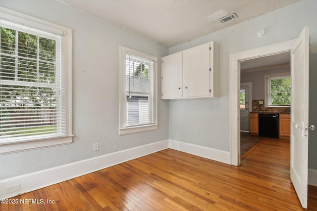 spare room with hardwood / wood-style floors and plenty of natural light