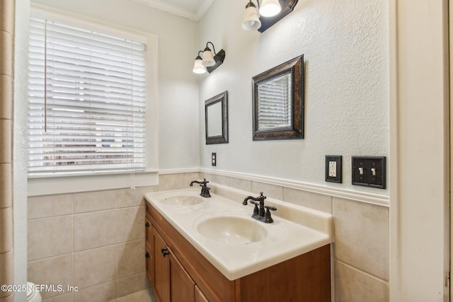 bathroom featuring crown molding, vanity, and tile walls