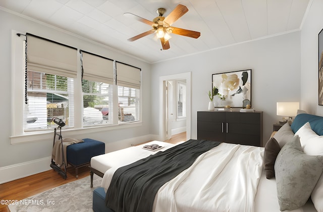 bedroom with crown molding, ceiling fan, and light hardwood / wood-style flooring