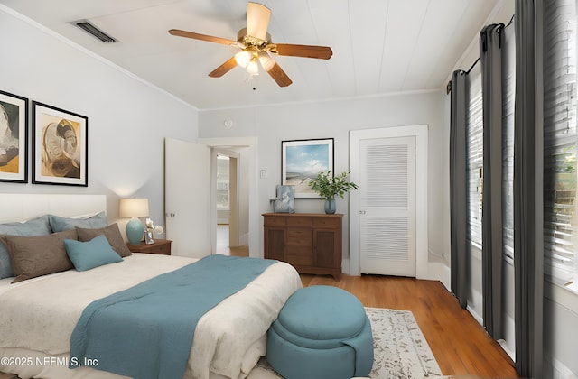 bedroom featuring crown molding, ceiling fan, and light wood-type flooring