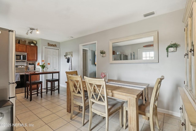 dining room with light tile patterned floors, visible vents, and baseboards