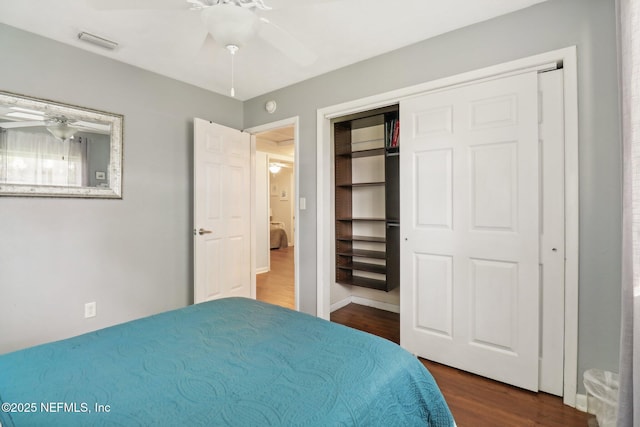 bedroom featuring ceiling fan, a closet, dark wood finished floors, and visible vents