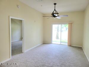 carpeted empty room featuring ceiling fan