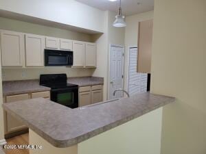 kitchen featuring pendant lighting, white cabinetry, kitchen peninsula, and black appliances