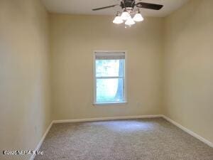 carpeted spare room featuring ceiling fan