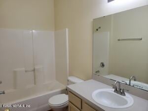 full bathroom with vanity, bathing tub / shower combination, and toilet