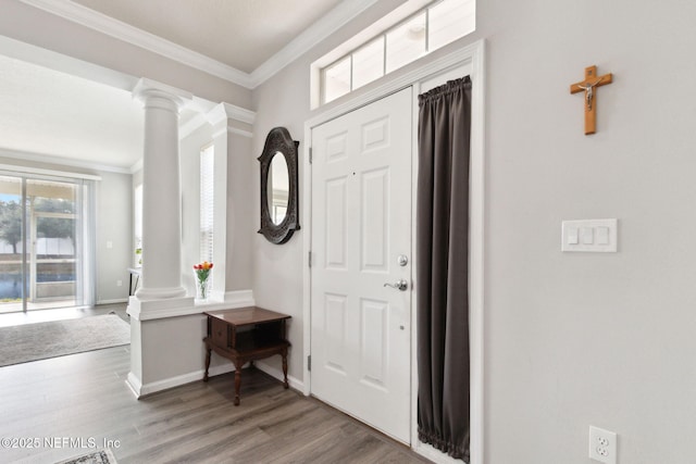 entryway featuring ornate columns, ornamental molding, and wood-type flooring