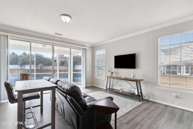 living room featuring ornamental molding, hardwood / wood-style floors, and a textured ceiling