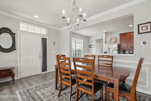 dining room featuring ornamental molding, light hardwood / wood-style floors, and a chandelier