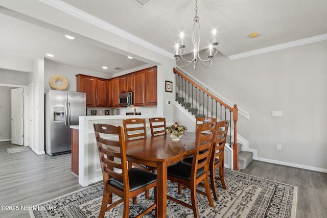 dining room with ornamental molding, a chandelier, and light hardwood / wood-style flooring