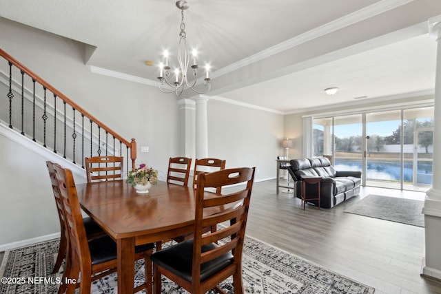 dining area featuring ornamental molding, decorative columns, wood-type flooring, and a water view