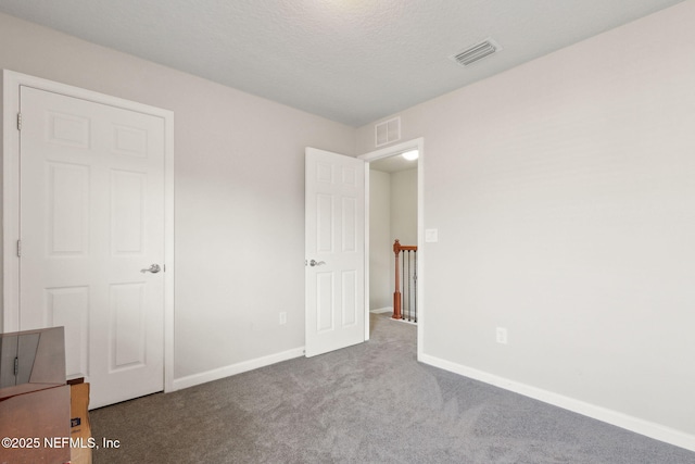 unfurnished bedroom with carpet floors and a textured ceiling