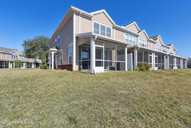 view of home's exterior with a sunroom and a lawn