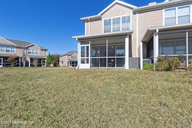 back of house with a sunroom and a yard