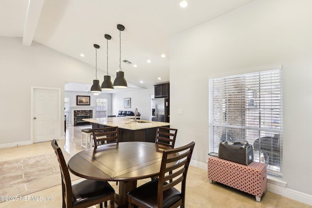 dining space with baseboards, a high end fireplace, beamed ceiling, high vaulted ceiling, and recessed lighting