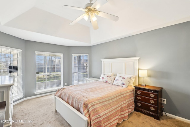 bedroom featuring baseboards, ceiling fan, a raised ceiling, and light colored carpet