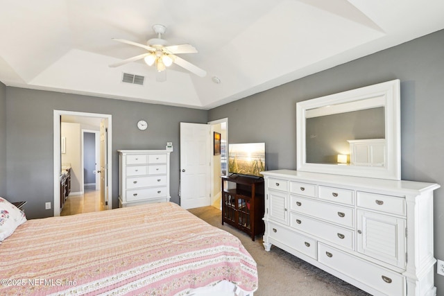 bedroom with a ceiling fan, a raised ceiling, visible vents, and light colored carpet