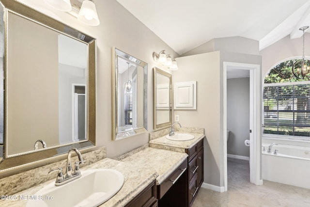 bathroom featuring baseboards, lofted ceiling, tile patterned floors, a garden tub, and vanity