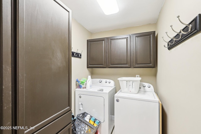 clothes washing area with washer and dryer and cabinet space