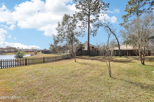 view of yard featuring a water view and a fenced backyard