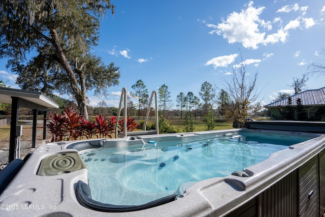 view of swimming pool with a hot tub