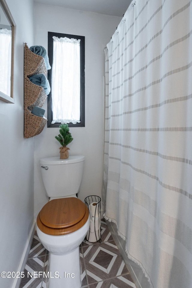 bathroom with a shower with curtain and toilet