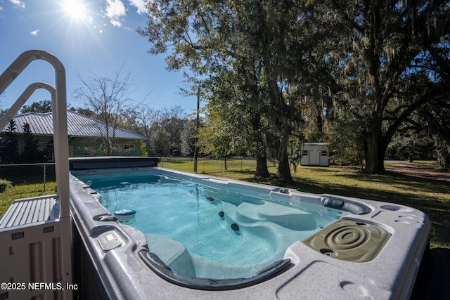 view of swimming pool featuring a shed and a lawn