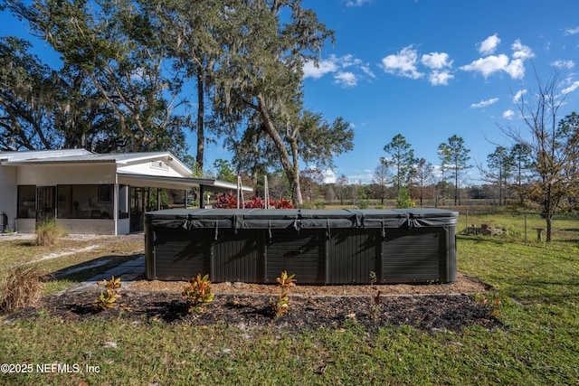 view of swimming pool featuring a yard, a hot tub, and a sunroom