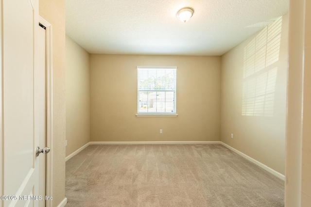 empty room featuring light carpet and a textured ceiling