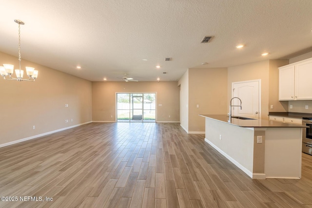 kitchen featuring white cabinetry, electric stove, sink, and light wood-type flooring