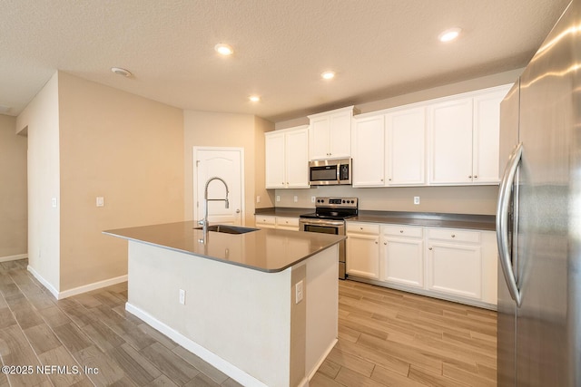 kitchen featuring sink, an island with sink, white cabinets, and appliances with stainless steel finishes