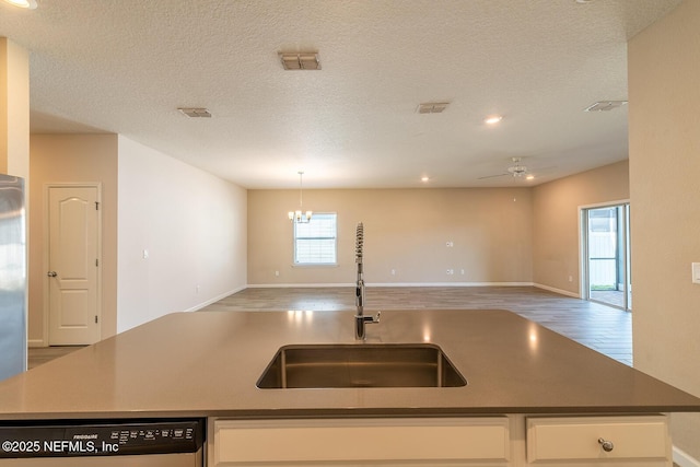 kitchen with sink, white cabinetry, wood-type flooring, black dishwasher, and a kitchen island with sink