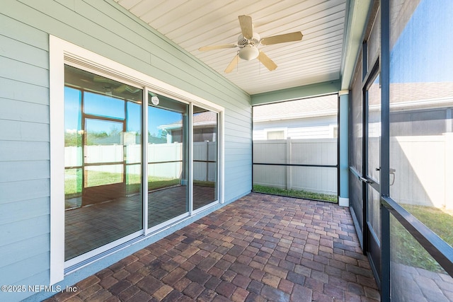 unfurnished sunroom featuring ceiling fan