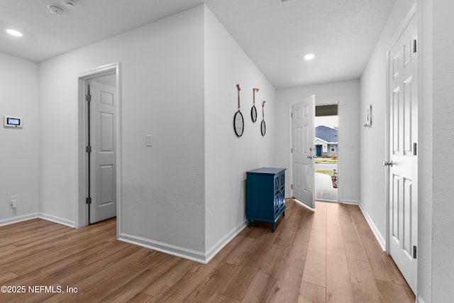 hallway with light hardwood / wood-style floors